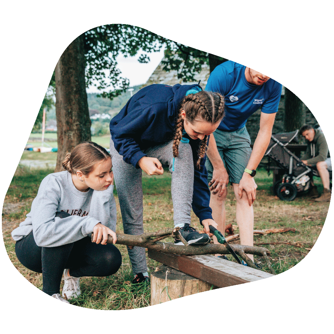 Teenagers cutting some tree bark